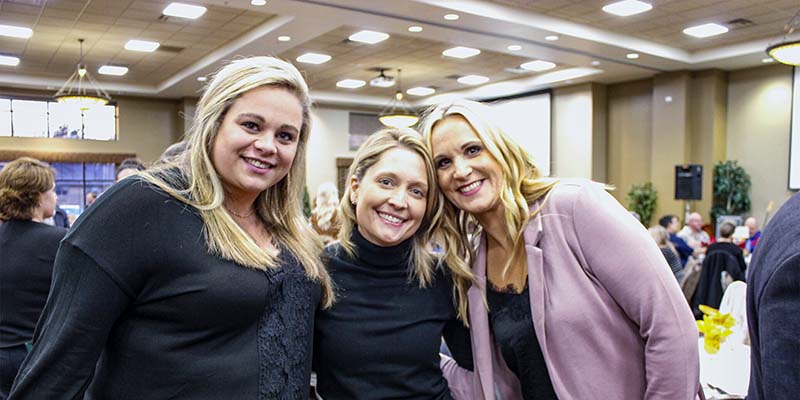 Three business women at Grand Rapids Area Chamber of Commerce annual meeting.